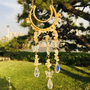 Detail of golden moon suncatcher with yellow crystal chips and a butterfly pendant