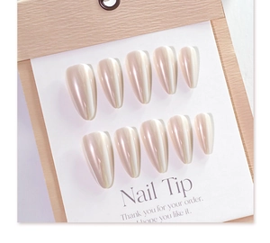 Detail of long almond pearlescent fake nails with laser white shimmer on white card