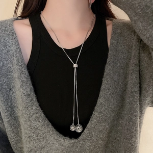 Detailed close-up of a silver stainless steel long necklace with hollow ball pendants