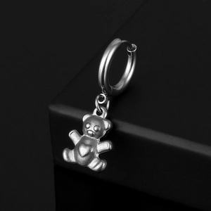 Detail of silver stainless steel hoop earring featuring a 3D teddy bear charm with heart
