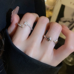 Close-up of sparkling star-shaped silver rings with zircon stones on a model's hand