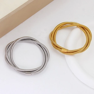 Detail of multi-layer snake chain bracelet in gold and silver finish with cylindrical clasp