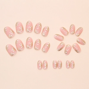 Set of 24 press-on nails with golden bamboo leaf patterns on soft pink oval tips