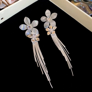 Detailed macro view of French style floral earrings with sparkling tassels and crystals