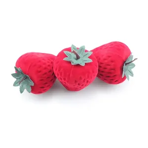 Three cute strawberry-shaped flocked velvet jewelry gift boxes on a clean white background