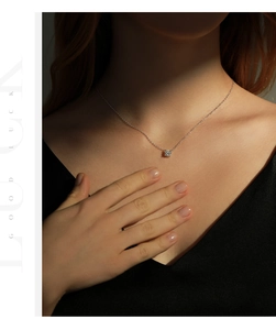 Vue détaillée d'un élégant pendentif en moissanite argenté porté par un mannequin