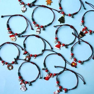 Flat lay of adjustable braided Christmas bracelets with Santa and snowman charms