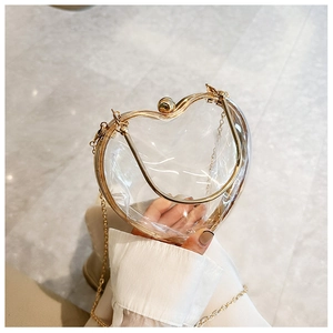 Close-up of heart-shaped acrylic clutch with gold metal frame and detachable chain