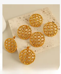 Detailed view of gold plated mesh link stud earrings on a textured stone display