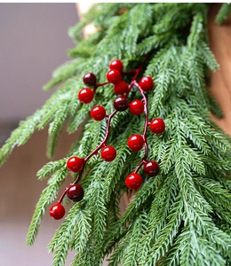 Macro shot of artificial red berries and green cypress needles for Christmas DIY crafts