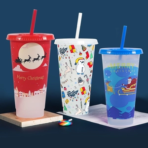 Three Christmas themed color-changing plastic cups with straws and festive patterns