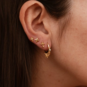Golden stainless steel cross earrings set with beaded and crystal studs on ear
