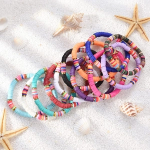 Set of 12 colorful clay bead friendship bracelets with starfish on beach sand
