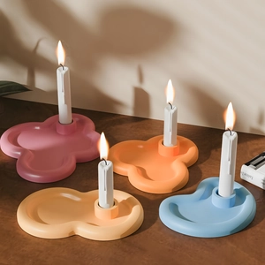 Top view of colorful cloud shaped ceramic candle holders with lit white taper candles