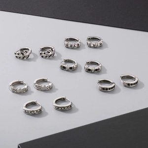 Detail of 6 pairs of silver earrings with black and white zircon heart and cross designs