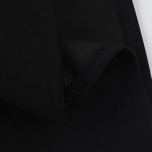 Macro detail of the high-quality black knitted fabric texture and overlock seam finish
