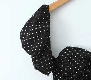 Détail d'une robe française à pois avec manches volantées sur un cintre en bois