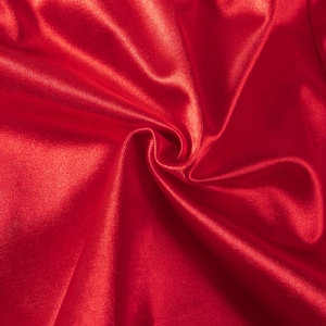 Macro detail of vibrant red satin shorts fabric showing silky texture and elegant folds
