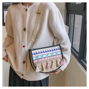 Detailed close-up of ethnic style crossbody bag with colorful embroidery and tassels