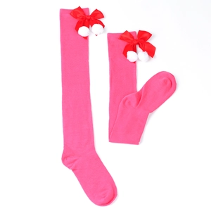 Detail of pink over-knee socks with red satin bows and white fuzzy pom-poms accents