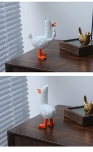 Dettaglio di una creativa statuetta di anatra in resina bianca con becco arancione