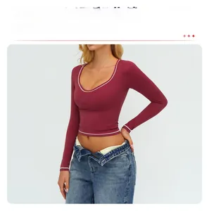 Dettaglio del top da yoga slim-fit con profili bianchi a contrasto e tessuto rosso vino