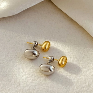 Detailed macro view of two-tone 18K gold and silver plated hammered pebble drop earrings