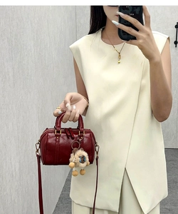 Mirror selfie showing a deep red mini Boston bag with a cute plush sheep charm detail