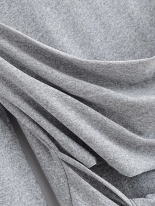 Close-up of grey knit fabric texture showing the soft blend and fine melange pattern