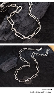 Macro view and full layout of textured silver rectangle link chain over dark charcoal
