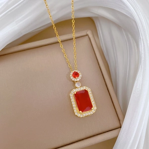Macro shot of a rectangular red gemstone pendant on a gold chain in a jewelry box