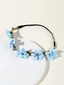 Detail of light blue floral headband with woven brown band and green leaves for bridal hair