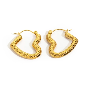 Macro detail of gold stainless steel heart hoop earrings with hammered finish