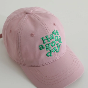 Nahaufnahme der rosa Kinder-Baseballkappe mit grünem Have a good day Stickerei.