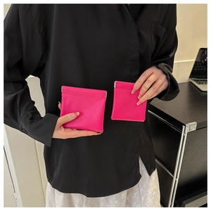 Close-up of vibrant fuchsia PU leather squeeze-to-open mini storage bag held by hand