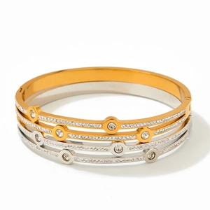 Stack of gold and silver stainless steel bangles with crystal inlay and geometric design