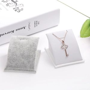 Collier avec pendentif clé en or rose et zircons sur un fond blanc épuré