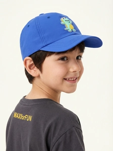 Detail einer königsblauen Kinder-Baseballkappe mit grünem Cartoon-Dinosaurier-Aufnäher