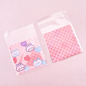 Detail of cute bear and pink checkered patterns on transparent self-sealing bags