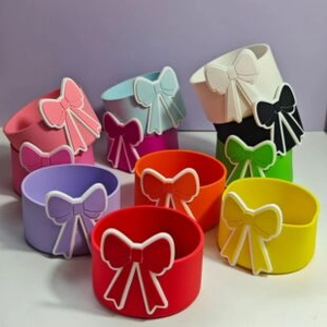 Close-up of colorful silicone boot sleeves with 3D bowknot designs for tumblers