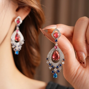 Macro detail of vintage teardrop earrings with red stone and colorful zircon accents