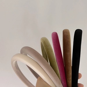 Macro detail of thick velvet headbands in various colors including beige and emerald