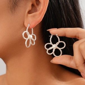 Silberne hohle Blumenohrringe mit Perle am Model für einen eleganten Retro-Stil