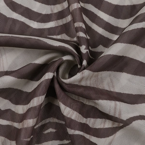 Gros plan du tissu mesh imprimé zèbre marron montrant une texture semi-transparente