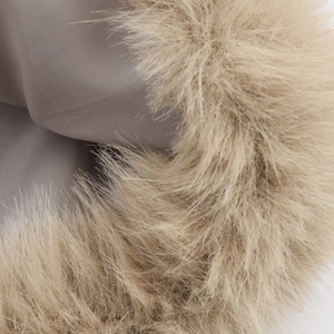 Macro detail of the light camel faux fur trim and soft plain fabric lining on the jacket