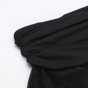 Detailansicht der schwarzen Netznaht und der plissierten Stoffstruktur am langärmligen Jumpsuit