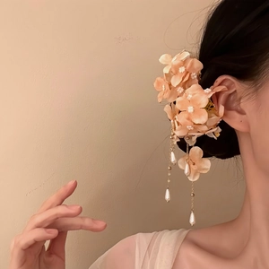 Close-up view of an elegant fabric flower hair clip with delicate hanging pearl tassels