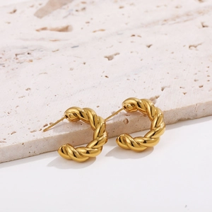 Macro shot of 18K gold plated C-shaped earrings with textured twisted rope design