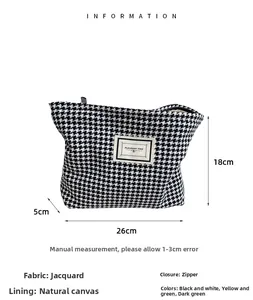 Detailed view of houndstooth toiletry bag featuring size labels and premium jacquard fabric
