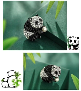 Macro shot of cute panda brooch with black and white rhinestones holding a pearl detail